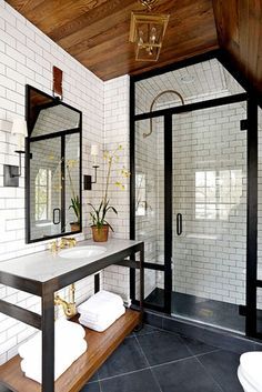 a bathroom with white tile and wood ceiling