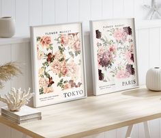 two flower market posters sitting on top of a wooden table