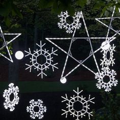 several snowflakes are hanging on the side of a building in front of trees