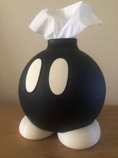 a black vase with white circles on it and a tissue paper dispenser