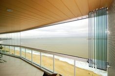 an ocean view from the balcony of a building with glass walls and floor to ceiling windows