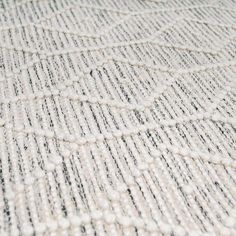 a close up view of a white and black rug with small circles on the floor