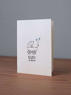 a baby on board card sitting on top of a wooden table