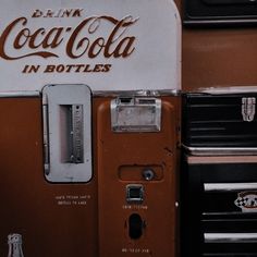 an old coca - cola machine sitting on top of a table