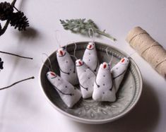 small white christmas ornaments on a plate next to twine spools