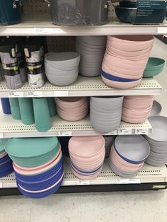 the shelves are filled with many different colored dishes