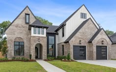 a large brick house with two garages on the front and one story above it