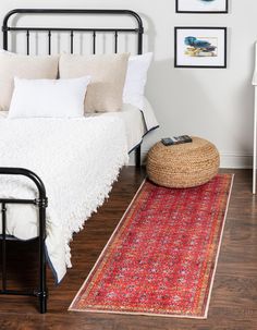 a bedroom with a bed, rug and pictures on the wall