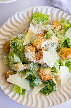 a white plate topped with pasta and broccoli covered in parmesan cheese