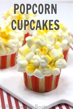 three cupcakes with white and yellow frosting on top sitting on a plate