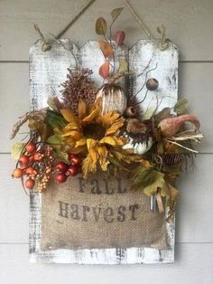 a fall harvest sign hanging on the side of a building with pumpkins, leaves and acorns