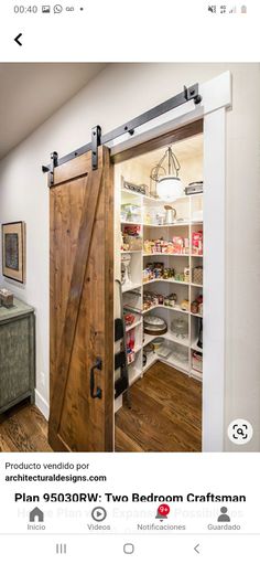 an open barn door in a kitchen with wooden floors and white walls, leading into the pantry