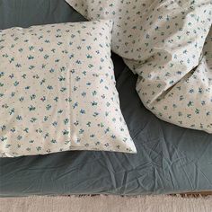 two pillows on top of a bed next to each other