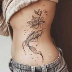 a woman's stomach with a flower and fish tattoo on it, while the lower part of her body is visible