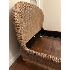 a wicker chair sitting on top of a hard wood floor next to a wall