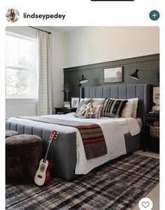 a bed room with a neatly made bed and a guitar