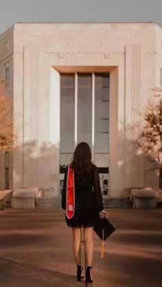 a woman walking in front of a building holding an umbrella