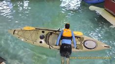 a man standing on top of a kayak in the water