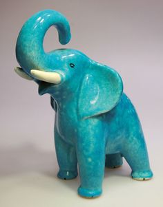 an elephant figurine with its trunk in the air and it's mouth open