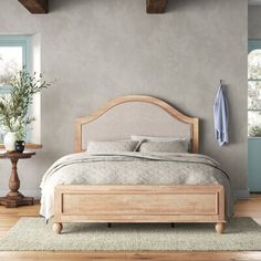 a bed sitting in a bedroom on top of a wooden floor next to a window