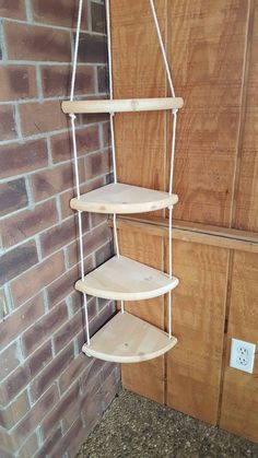 a wooden shelf next to a brick wall with shelves on each side and an electrical outlet in the middle