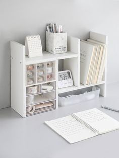 a white shelf with various items on it and a clock next to the bookcase