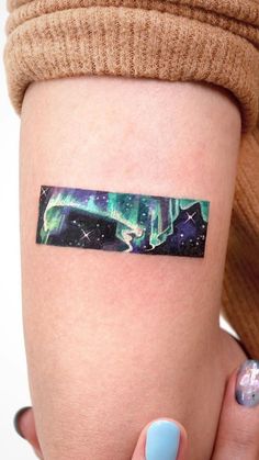 a woman's arm with an aurora bore tattoo on the left side of her arm