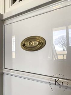 an old fashioned white cabinet with brass knobs