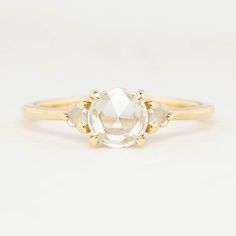 the three stone engagement ring in yellow gold with an oval cut diamond center and two pear shaped