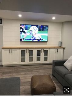 a large flat screen tv mounted to the side of a wall in a living room