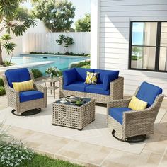 a patio with blue and yellow furniture next to a swimming pool in the back yard