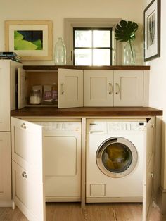 a washer and dryer sitting in a room next to each other on top of a wooden floor