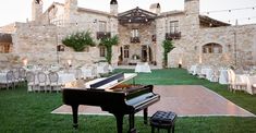 a grand piano sits in the middle of an outdoor wedding reception set up with tables and chairs