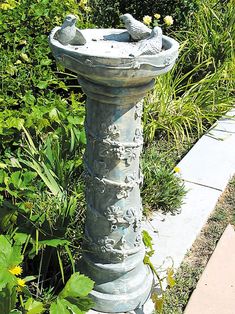 a bird bath sitting in the middle of a garden