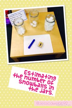 a wooden table topped with two glasses filled with water and ice next to a sign that says estimating the number of snowballs in the jars