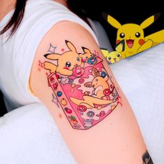 a woman with a tattoo on her arm has a pikachu in a gift box