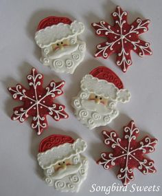 christmas cookies decorated like santa claus and snowflakes on a white table with the words songbird sweets written below