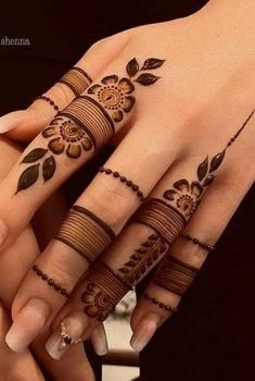 two hands with henna tattoos on them