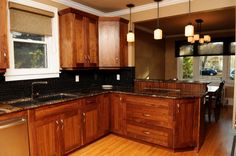 a kitchen with wooden cabinets and black counter tops