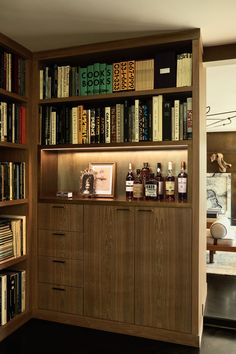 a bookshelf filled with lots of books and bottles