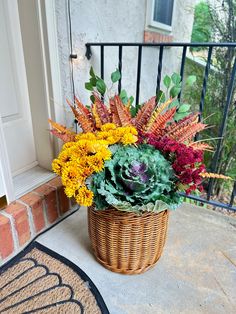 a basket filled with lots of flowers sitting on top of a porch