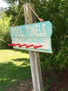 a pool towel sign hanging from a wooden pole