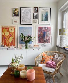 a living room with pictures on the wall and candles on the table in front of it