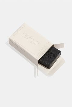 a black soap bar in a white box