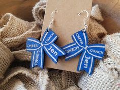 PERSONALIZED CHEERLEADER BOW  EARRINGS  Cheer Mom Materials: Wood 3mm thick Paint Engraved on both sides Sterling silver hooks  Dimensions: 1.5" diameter  All of our earrings are made to order with love and care in our Florida shop  HOW TO ORDER Please choose your wood color and enter your cheerleaders name and team in the PERSONALIZATION  section Custom Name White Earrings As A Gift, Customizable Blue Jewelry For Mother's Day, Cheer Earrings, Sports Earrings, Cheer Coach Gifts, Cheerleading Bows, Thick Paint, Cheer Coach, Pom Pom Girl