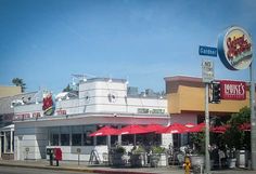 the outside of a restaurant with red umbrellas