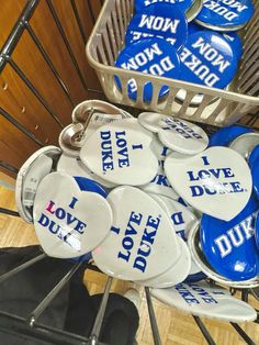 a shopping cart filled with lots of blue and white buttons that say i love duke