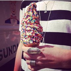 a person holding an ice cream cone with sprinkles