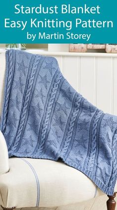 a blue knitted blanket sitting on top of a white couch