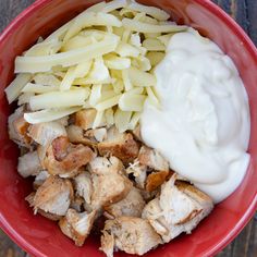 a red bowl filled with meat and cheese